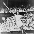 Althea Gibson, of New York, reaching high for shot during women's singles semifinal match against Christine Truman, of England, in All England Lawn Tennis Championships at Wimbledon, England, July 4, 1957