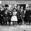 School strike, a group of children and a woman assembled on a sidewalk in front of a Tilden school entrance