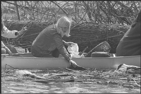 Girl Scout in canoe, picking trash out of the Potomac River during Earth Week 1970 April 22
