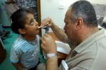 An Iraqi doctor checks a child's throat