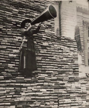 Woman with megaphone standing on pile of books for ALA campaign